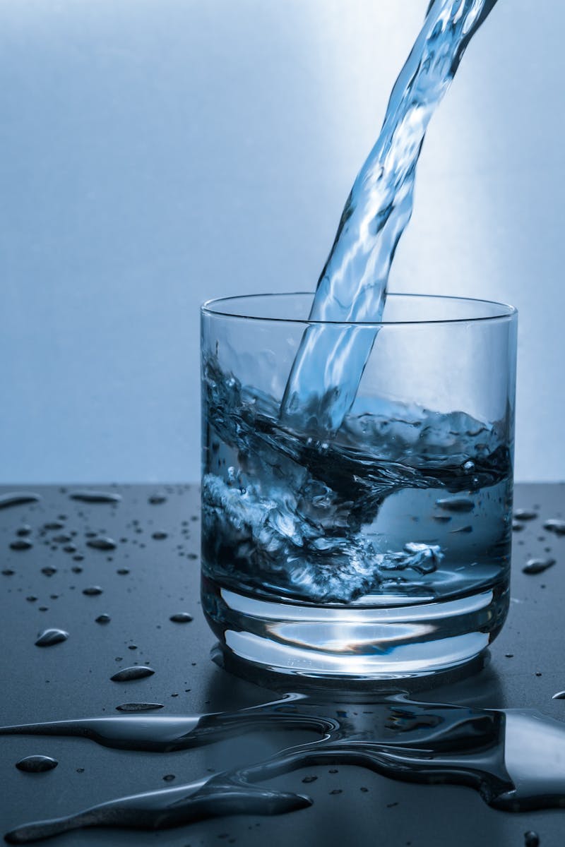 High-quality image of water being poured into a glass, illustrating hydration and purity.
